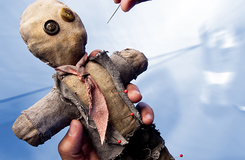Photo of Businessman making voodoo to co-worker
